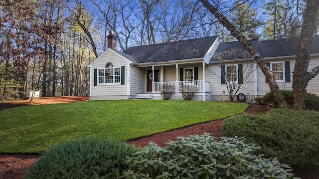 ranch-style home featuring a porch, a front lawn, and a chimney