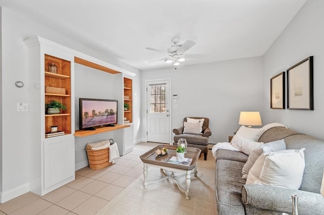 living area with ceiling fan, a baseboard radiator, baseboards, and light tile patterned flooring