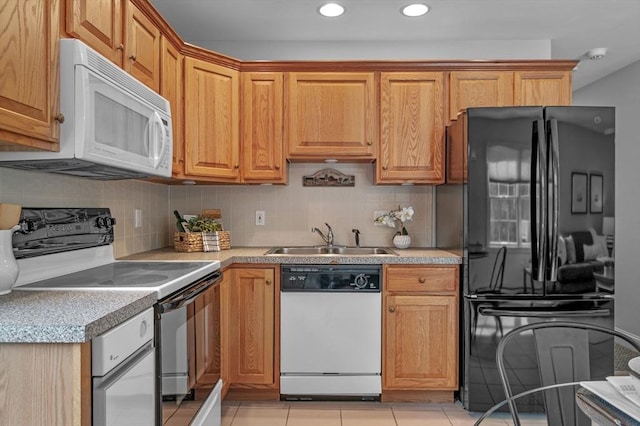 kitchen with decorative backsplash, white appliances, light countertops, and a sink