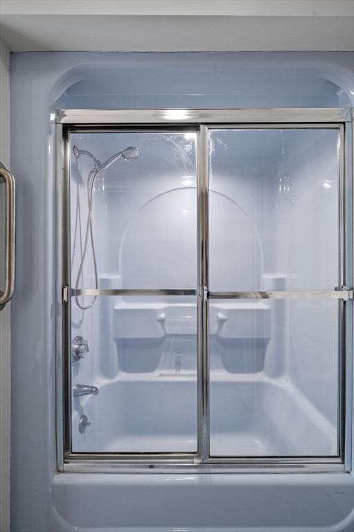 bathroom with bath / shower combo with glass door