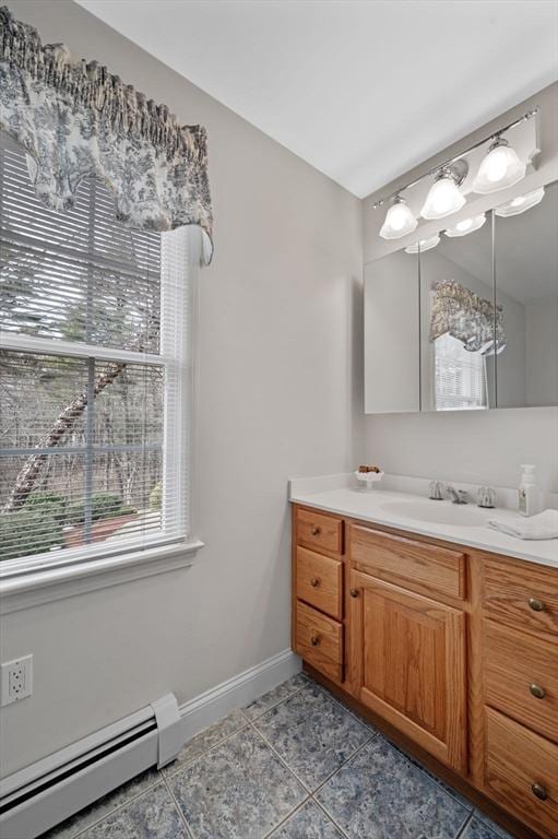 bathroom with tile patterned floors, baseboards, baseboard heating, and vanity