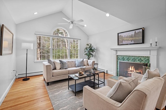 living area featuring baseboard heating, a tile fireplace, wood finished floors, and a baseboard radiator