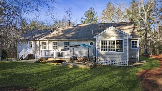 rear view of property featuring a vegetable garden, a lawn, and a deck