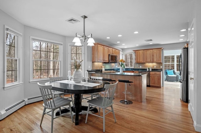 dining room with an inviting chandelier, recessed lighting, visible vents, and light wood finished floors