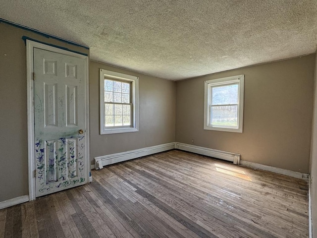 empty room featuring dark wood-style floors, a textured ceiling, and baseboards
