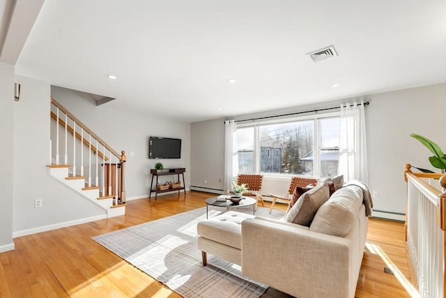 living room featuring a baseboard radiator and light hardwood / wood-style floors