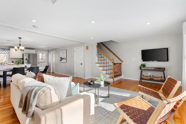 living room featuring light hardwood / wood-style floors and a notable chandelier