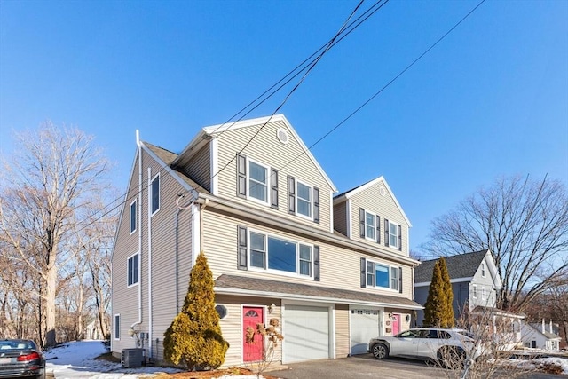 view of front of home featuring a garage and central AC