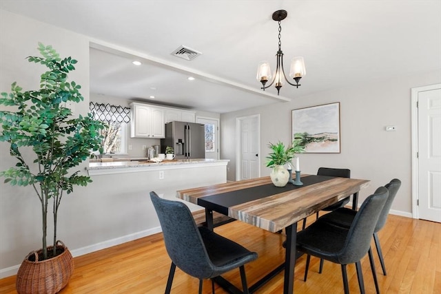 dining space with an inviting chandelier and light hardwood / wood-style floors