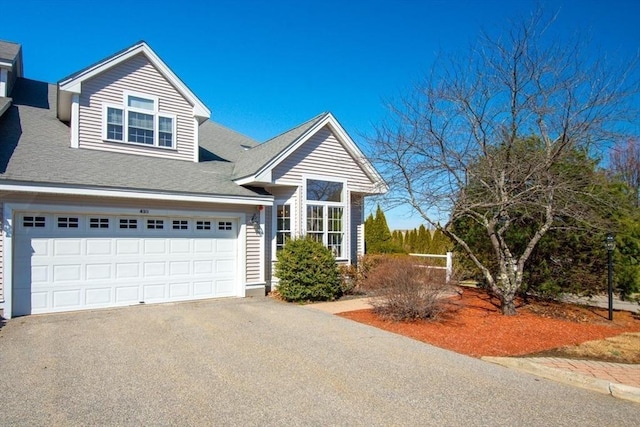 view of front of property with aphalt driveway and a shingled roof