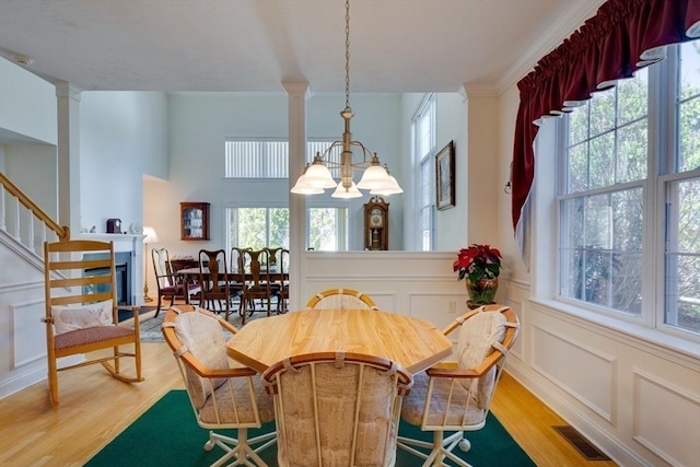 dining area with a wealth of natural light, visible vents, light wood-type flooring, and a decorative wall