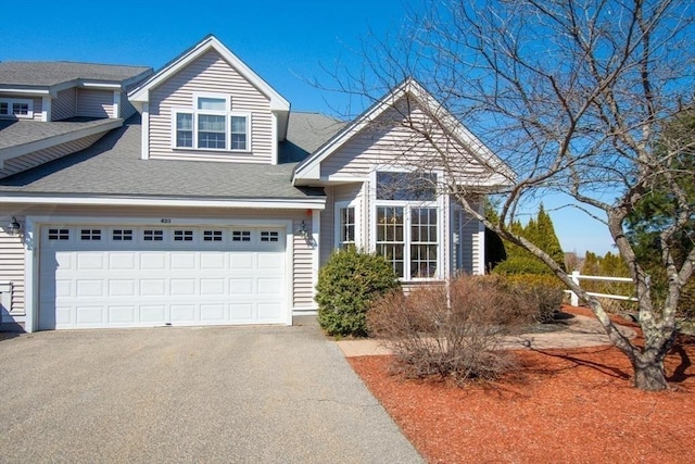 view of front of property with aphalt driveway, a garage, and roof with shingles