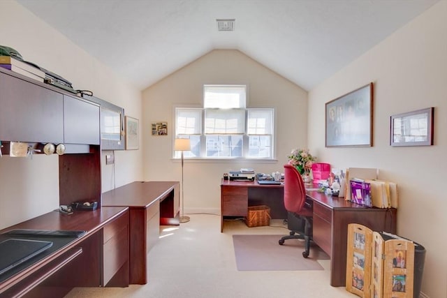 carpeted home office featuring visible vents and vaulted ceiling