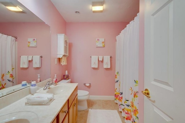 full bath with tile patterned flooring, baseboards, toilet, double vanity, and a sink