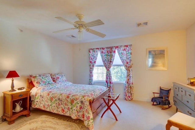 bedroom with visible vents, baseboards, light colored carpet, and ceiling fan