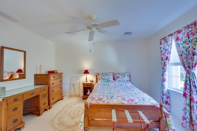 bedroom featuring light carpet, visible vents, and a ceiling fan