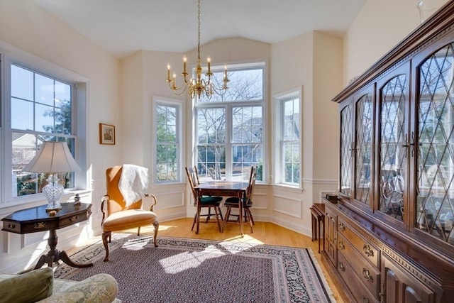 sitting room with a chandelier, a decorative wall, a healthy amount of sunlight, and light wood-type flooring