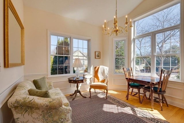 dining space featuring a decorative wall, wainscoting, and a chandelier