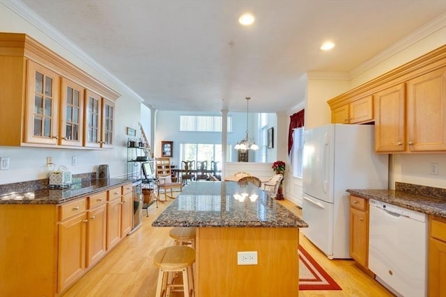 kitchen featuring white appliances, a breakfast bar area, light wood-style flooring, ornamental molding, and glass insert cabinets