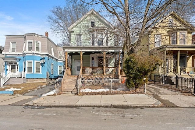 victorian-style house with fence and a porch