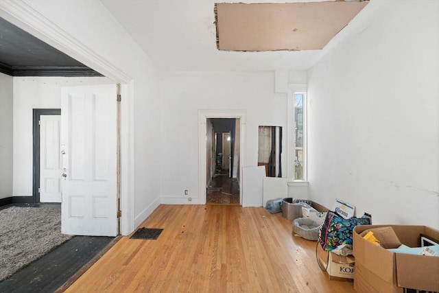 empty room with visible vents, baseboards, and wood finished floors