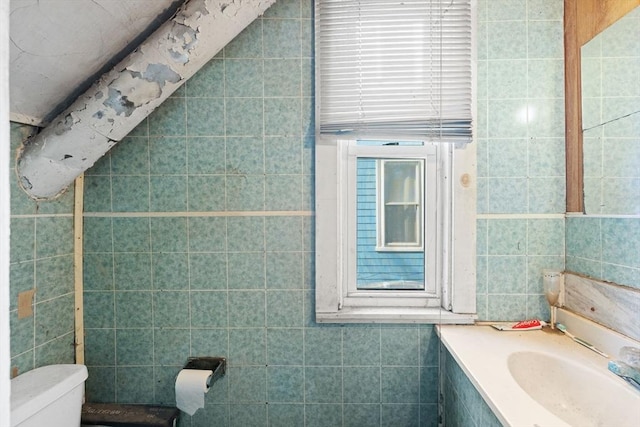 half bath featuring toilet, tile walls, and vanity