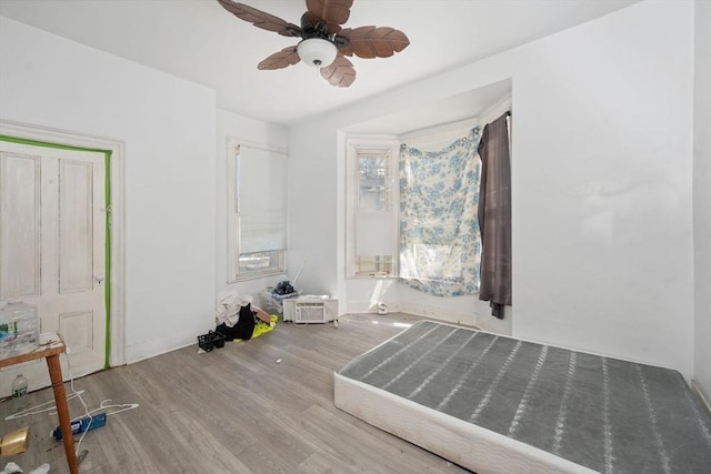 unfurnished bedroom with ceiling fan, baseboards, and wood finished floors