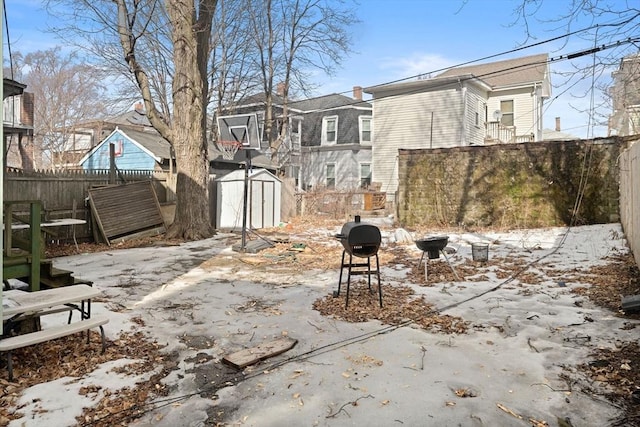 view of patio with an outbuilding, a storage shed, a grill, a residential view, and a fenced backyard