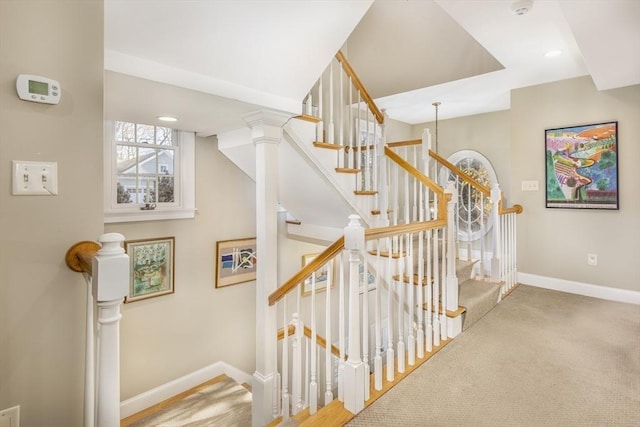 stairway with decorative columns and carpet