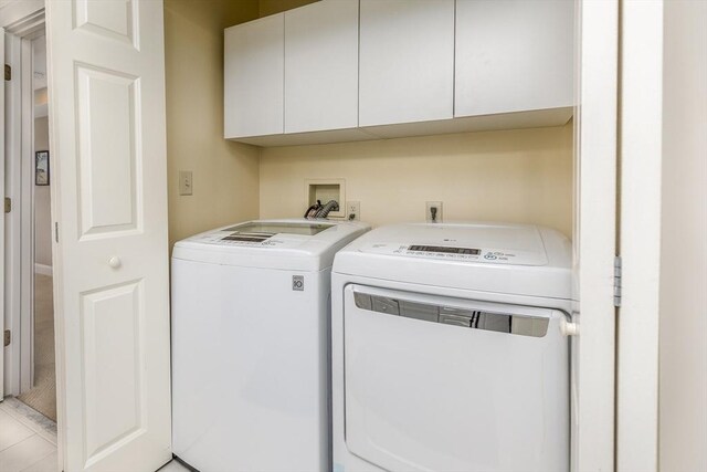 laundry room featuring cabinets, independent washer and dryer, and light tile patterned floors