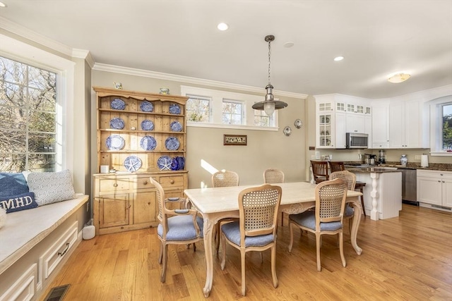 dining area featuring ornamental molding and light wood-type flooring