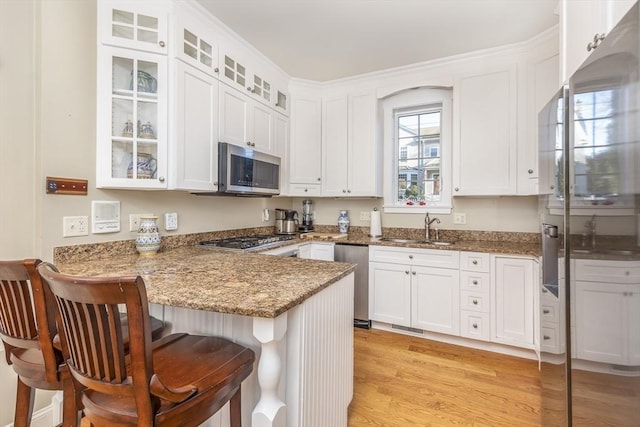 kitchen featuring kitchen peninsula, appliances with stainless steel finishes, plenty of natural light, and sink