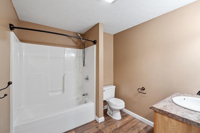 bathroom featuring vanity, toilet, bathtub / shower combination, baseboards, and wood finished floors