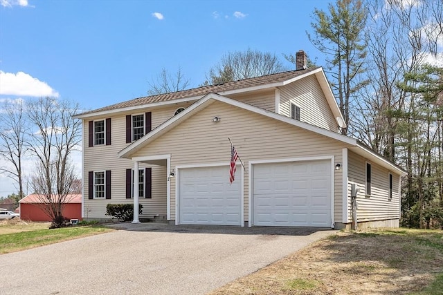view of front of property featuring a chimney, a garage, and aphalt driveway