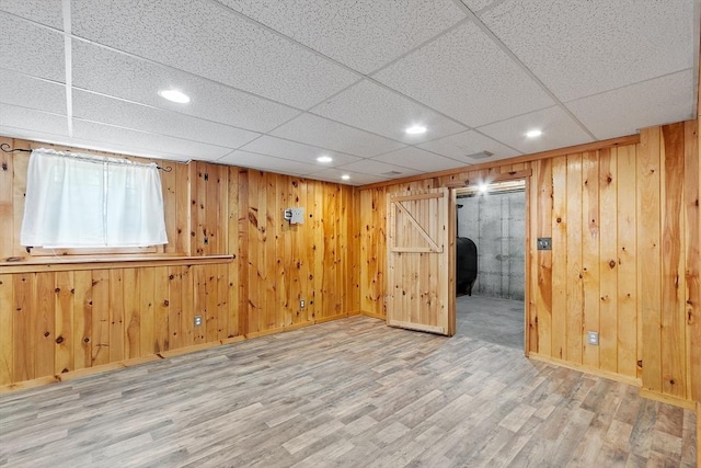 below grade area featuring recessed lighting, wood walls, wood finished floors, and baseboards