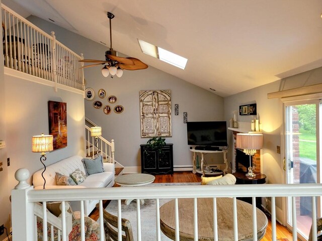 30 Ridgewood Ln, Quincy, MA 02169 - living room with a baseboard radiator, a ceiling fan, wood finished floors, a skylight, and high vaulted ceiling
