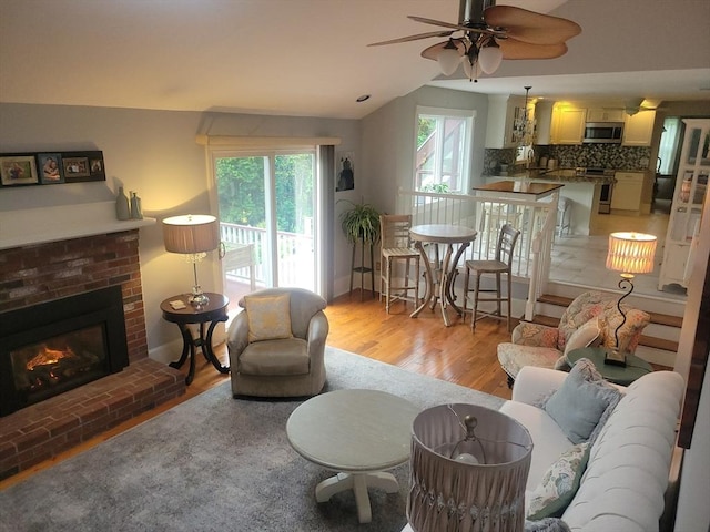 30 Ridgewood Ln, Quincy, MA 02169 - living room with lofted ceiling, a fireplace, light wood finished floors, and a ceiling fan
