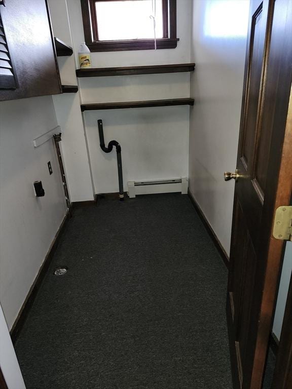 interior space featuring dark colored carpet and a baseboard heating unit