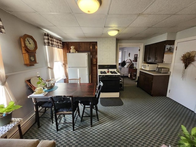 carpeted dining space with a drop ceiling