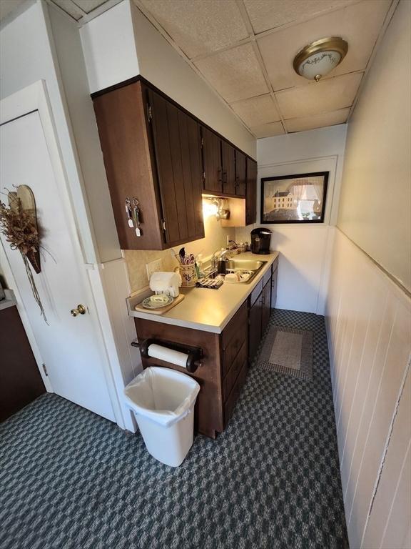 interior space featuring dark brown cabinetry and a drop ceiling