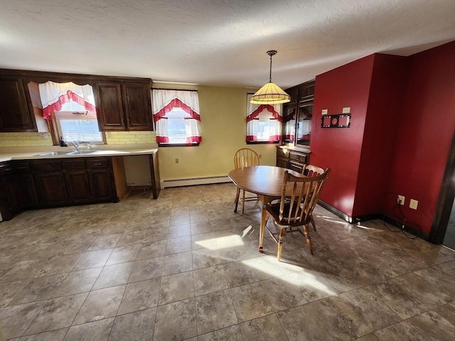 dining space featuring a wealth of natural light, sink, and a baseboard heating unit