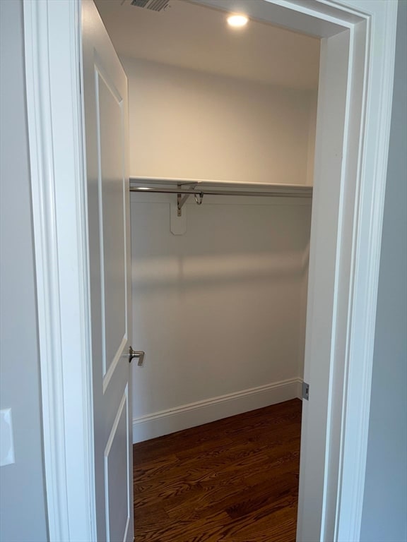 spacious closet featuring dark hardwood / wood-style flooring