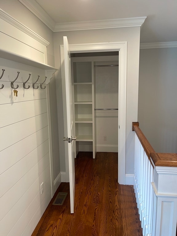 interior space featuring ornamental molding and dark wood-type flooring