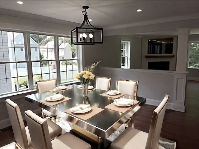 dining area featuring a healthy amount of sunlight, wood-type flooring, and an inviting chandelier