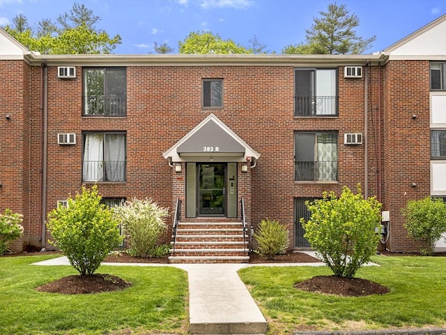 382 Great Rd Unit B103, Acton, MA 01720 - townhome / multi-family property with brick siding, a front yard, entry steps, and a wall mounted air conditioner