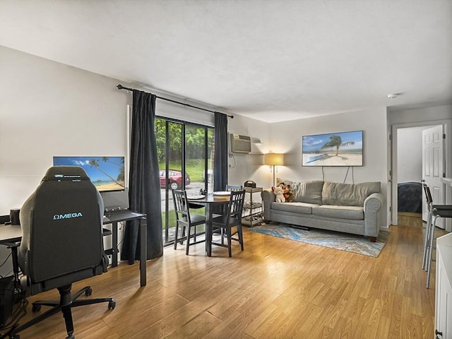 382 Great Rd Unit B103, Acton, MA 01720 - living area with wood finished floors, a desk, and a wall mounted air conditioner