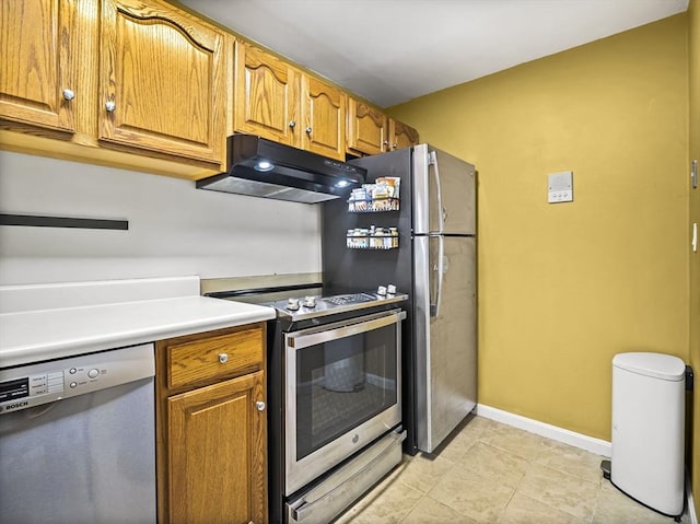 382 Great Rd Unit B103, Acton, MA 01720 - kitchen featuring appliances with stainless steel finishes, under cabinet range hood, baseboards, brown cabinetry, and light countertops