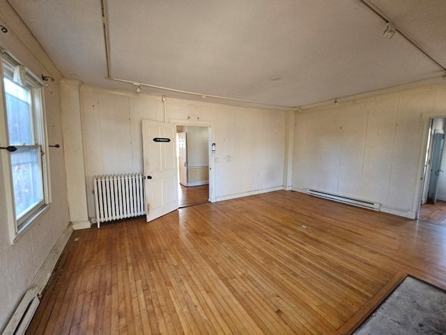 spare room featuring a baseboard radiator, radiator heating unit, baseboard heating, and hardwood / wood-style floors