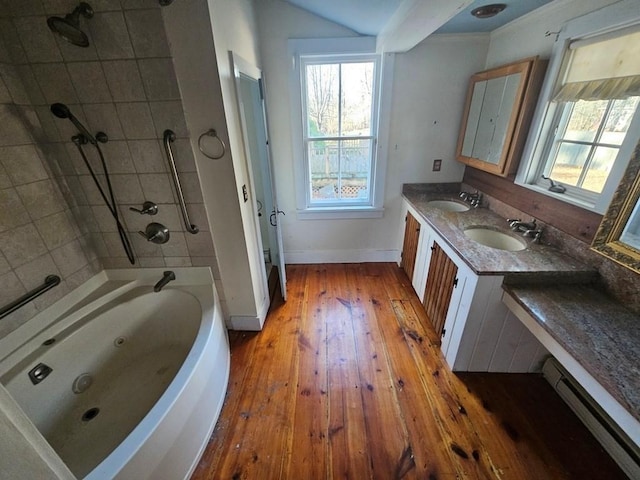 full bath with double vanity, hardwood / wood-style floors, baseboard heating, and a sink