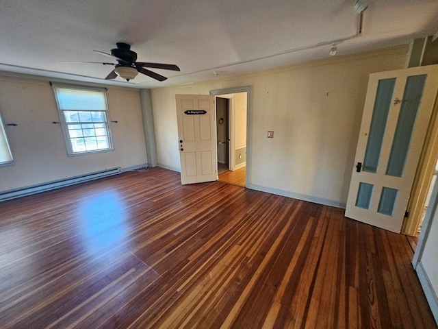 spare room featuring a ceiling fan, a baseboard heating unit, baseboards, and wood finished floors